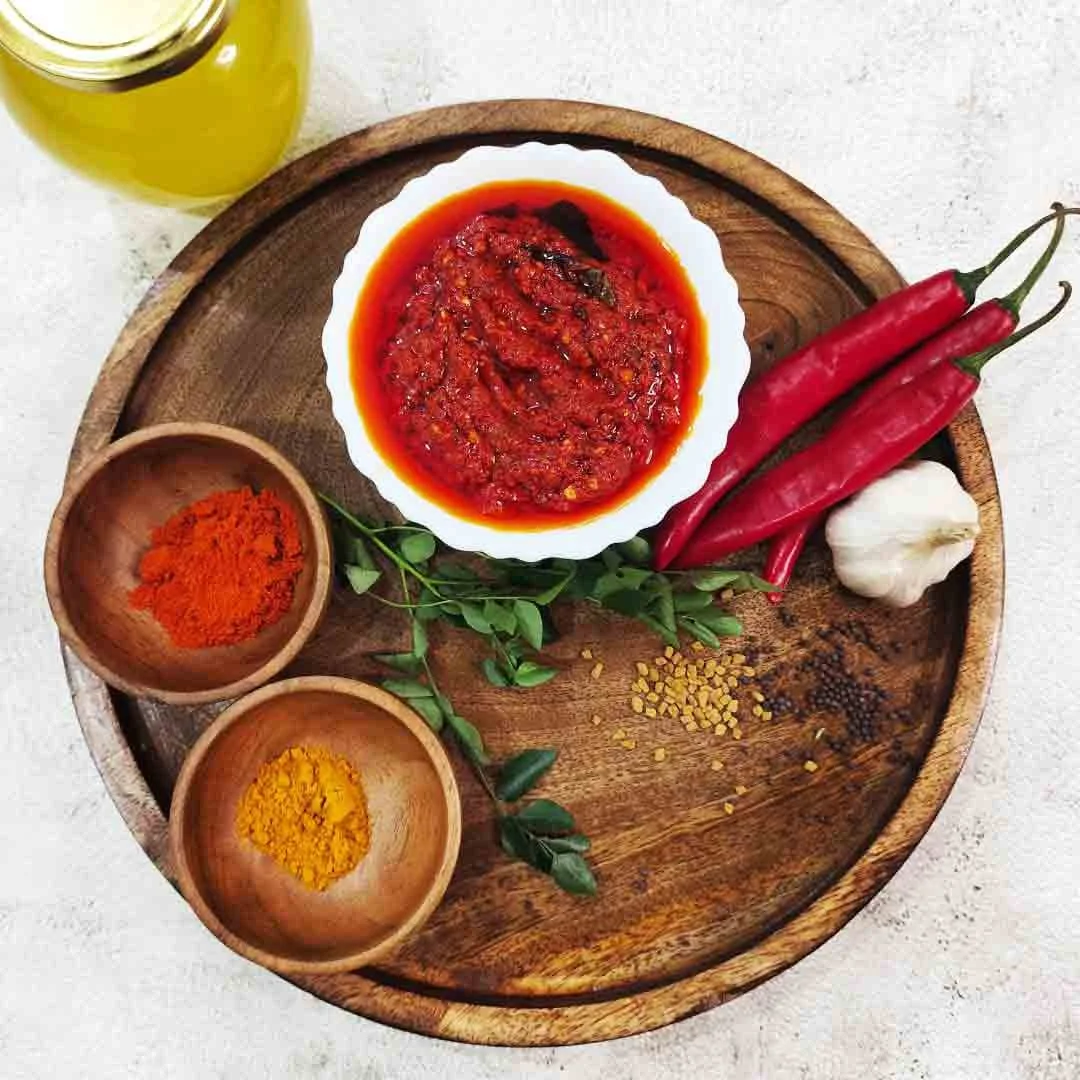 A jar of spicy homemade red chilli pickle, rich in color and flavor, made with fresh red chillies and aromatic Indian spices.